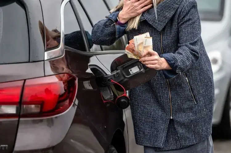 high inflation and soaring gas prices represented in a picture of a woman holding euro notes. 