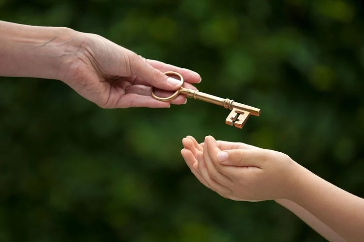 I genitori che iniziano a risparmiare il prima possibile per il futuro dei propri figli per offrire loro una rete di salvataggio rappresentati con la fotografia di un adulto che passa una chiave dorata a un bambino.