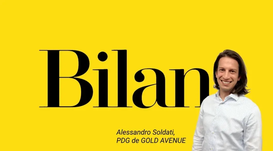 Alessandro Soldati, CEO von GOLD AVENUE in weißem Hemd auf gelbem Hintergrund mit Bilan schreibt