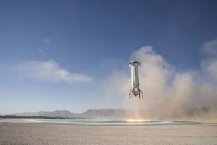Amazon rocket ship with Jeff Bezos onboard lifting off from landing pad in the desert to go into space