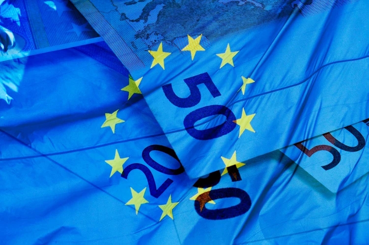 Banconote da 20 e da 50 euro con la bandiera dell’UE sullo sfondo.