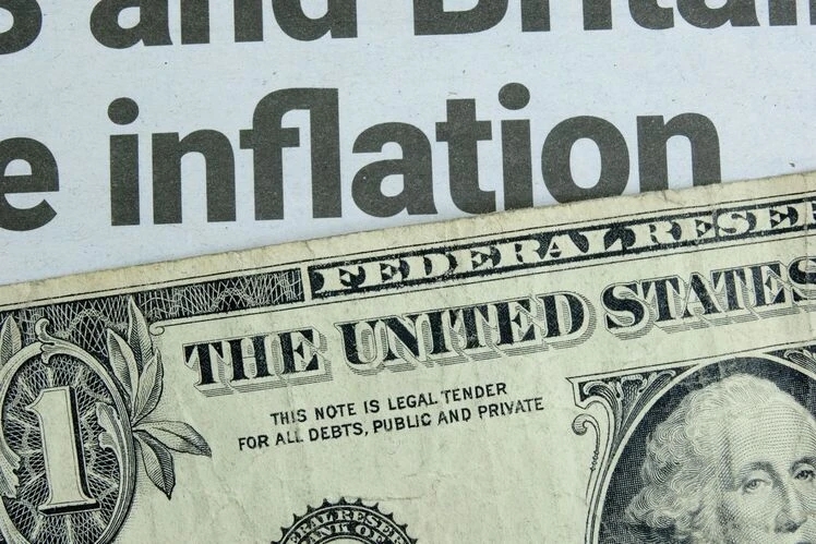 Una banconota in dollari USA sotto un titolo di giornale sull