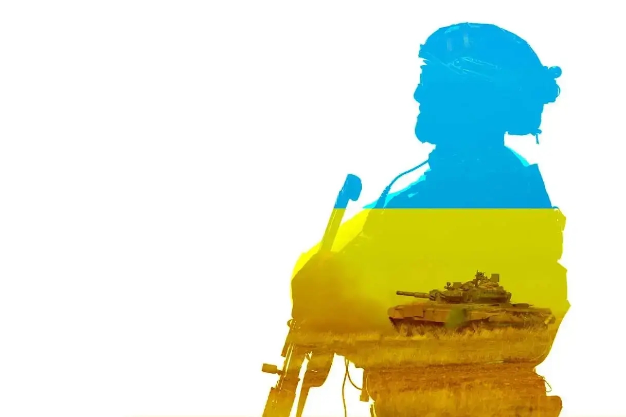 a silhouette of a solder in Ukraine flag colors and a tank crossing the field after Russian President Vladimir Putin announced a full-scale military operation in Ukraine