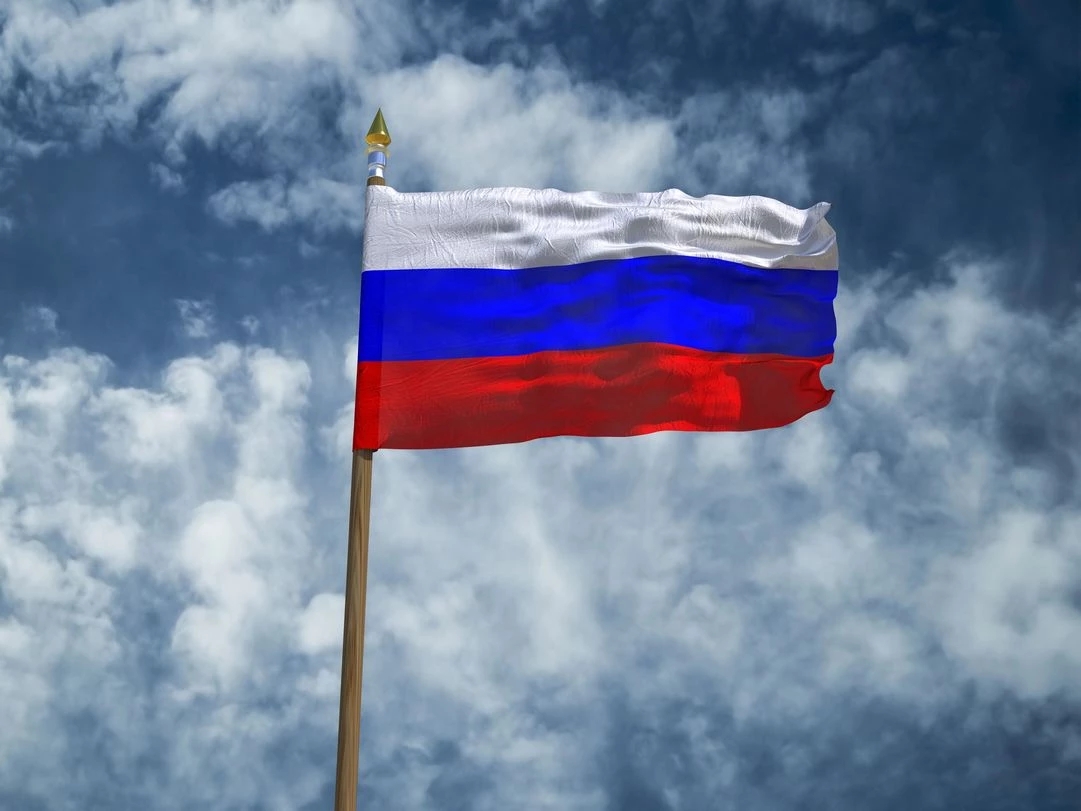 La bandiera russa che sventola nel cielo azzurro in occasione della decisione di Mosca di aggiungere lingotti d’oro al suo fondo sovrano e di rimuovere tutti gli asset in dollari americani.