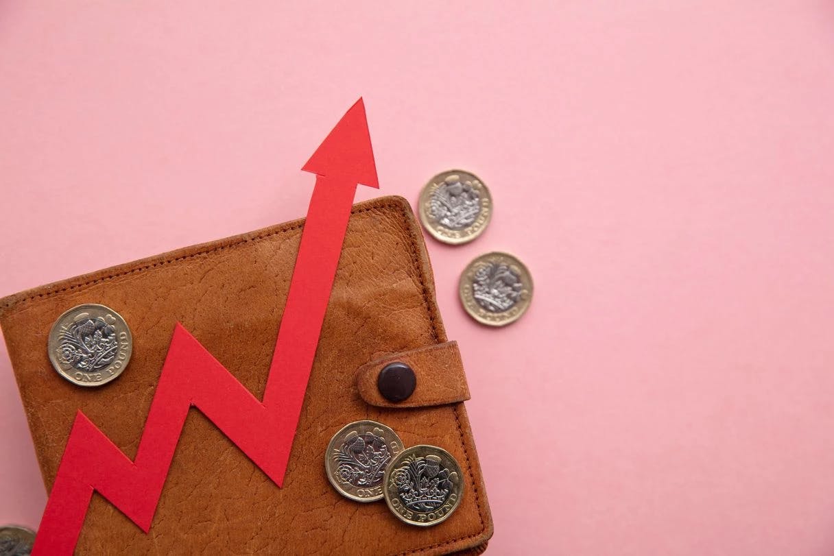 Die steigende Inflation beeinträchtigt das Verbrauchervertrauen in der EU und den USA, wie das Bild einer Brieftasche und eines nach oben zeigenden roten Pfeils zeigt.
