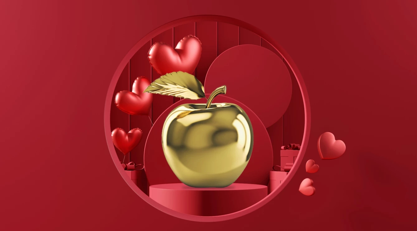 Una mela d’oro in un cerchio con palloncini rossi a forma di cuore sullo sfondo.