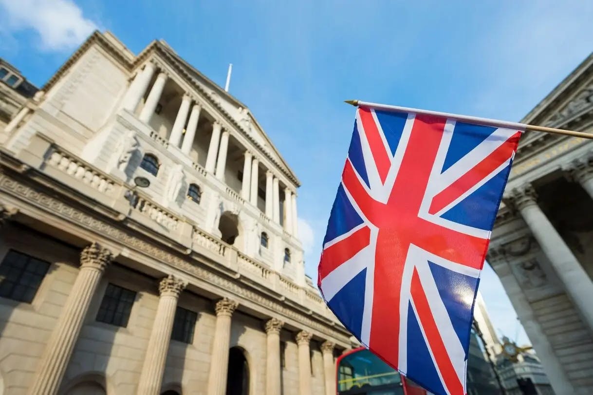 Bank of England building in London with the UK flag