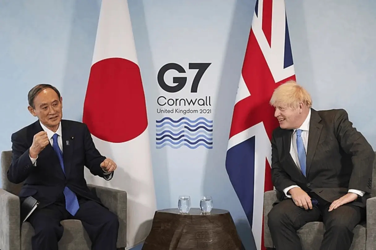 Il primo ministro britannico Boris Johnson e il suo omologo giapponese Yoshihide Suga in attesa di un incontro ai margini del vertice G7 in Cornovaglia con le bandiere giapponese e britannica sullo sfondo