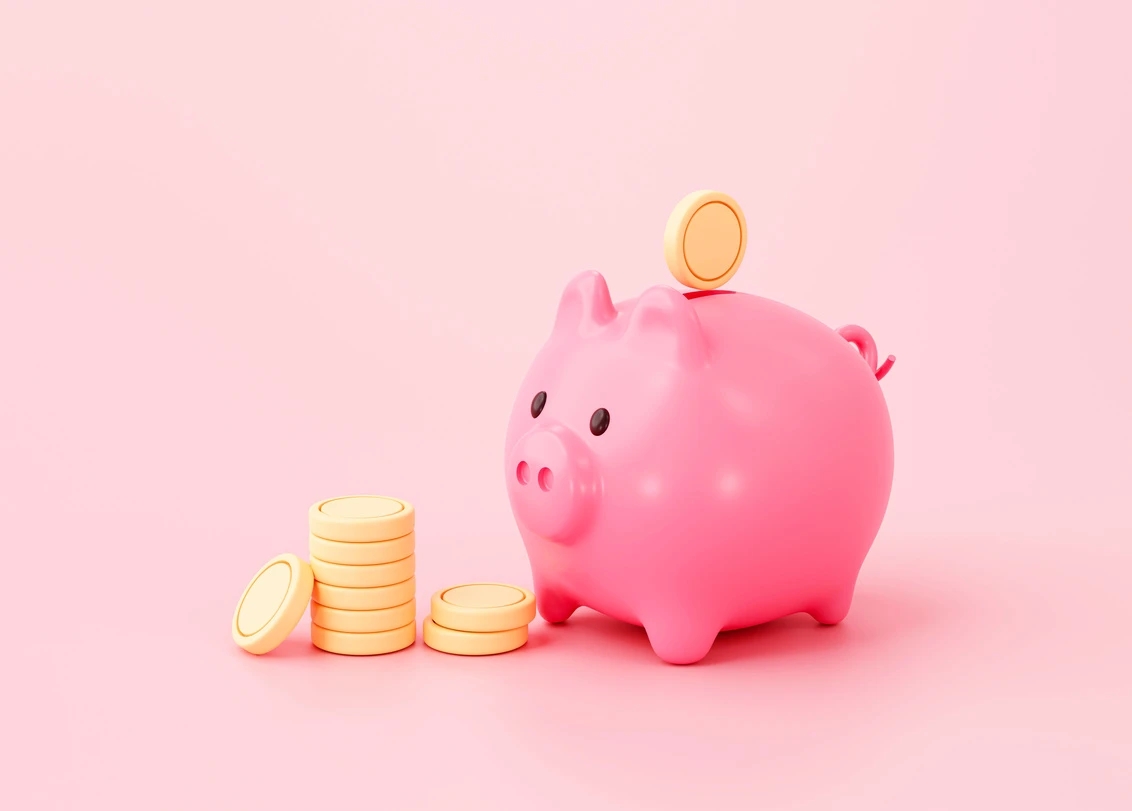 A piggy bank with rubber gold coins on a pink background