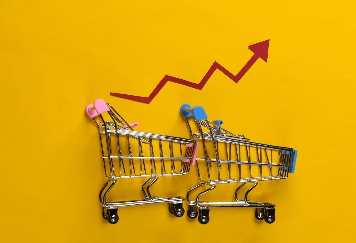 Steigende Lebensmittelpreise, ein roter Pfeil steigt über zwei Einkaufswagen auf goldenem Hintergrund