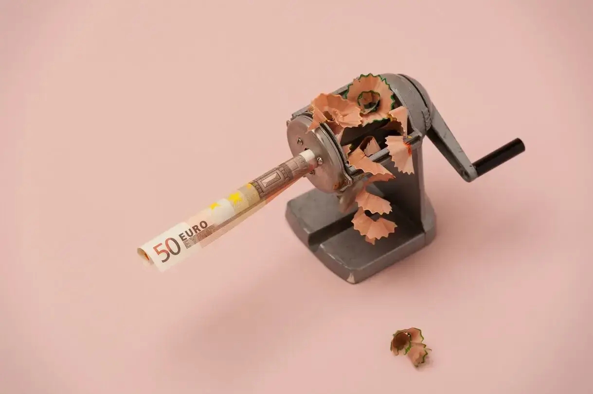 pencil sharpener with a 50 euro bill on a pink background