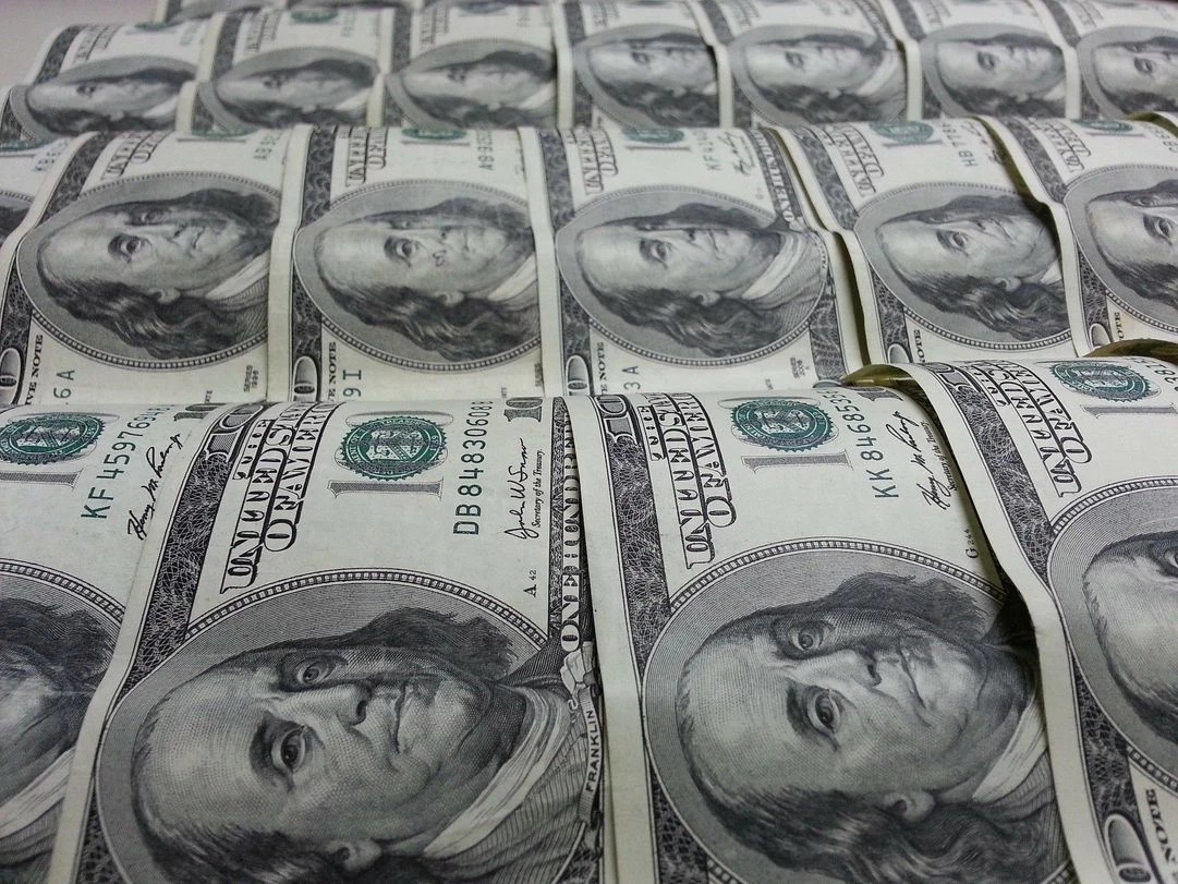 Un stock de billets de 100 dollars US imprimés symbolisant l'impression monétaires excessive par les banques centrales menant à l'inflation