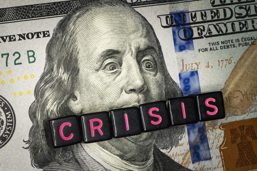the word CRISIS on top of a dollar bill