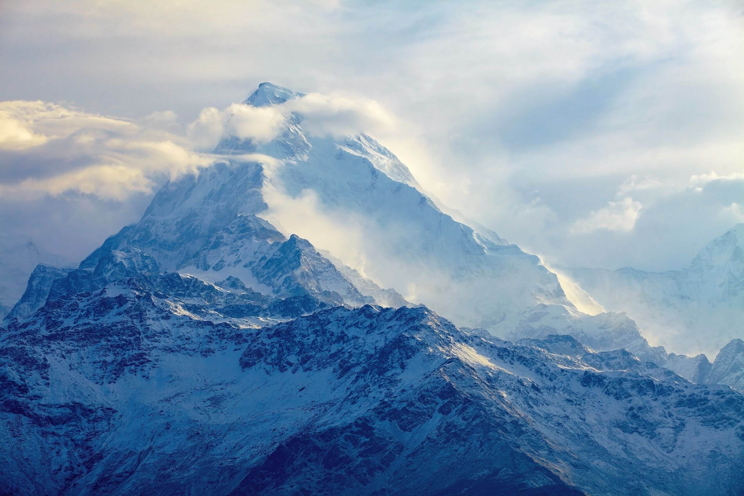 Previsioni 2021 per i metalli preziosi un'immagine che mostra montagne blu circondate da nebbia e nuvole