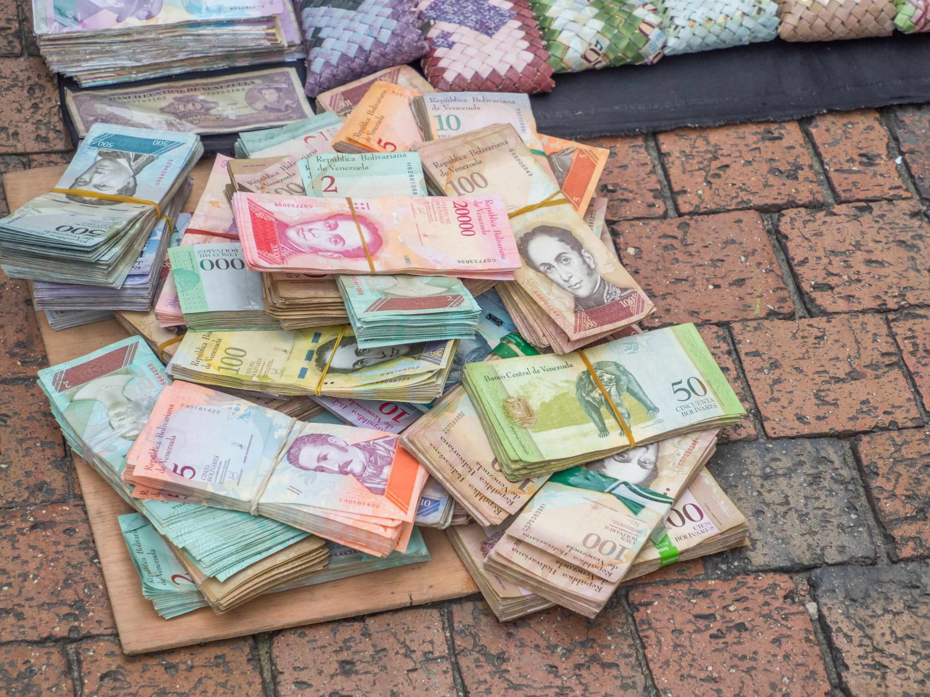 L’impatto dell’inflazione sulla vita reale: il caso del Venezuela Il bolivar venezuelano abbandonato sul marciapiede vicino a borsette realizzate con la valuta nazionale