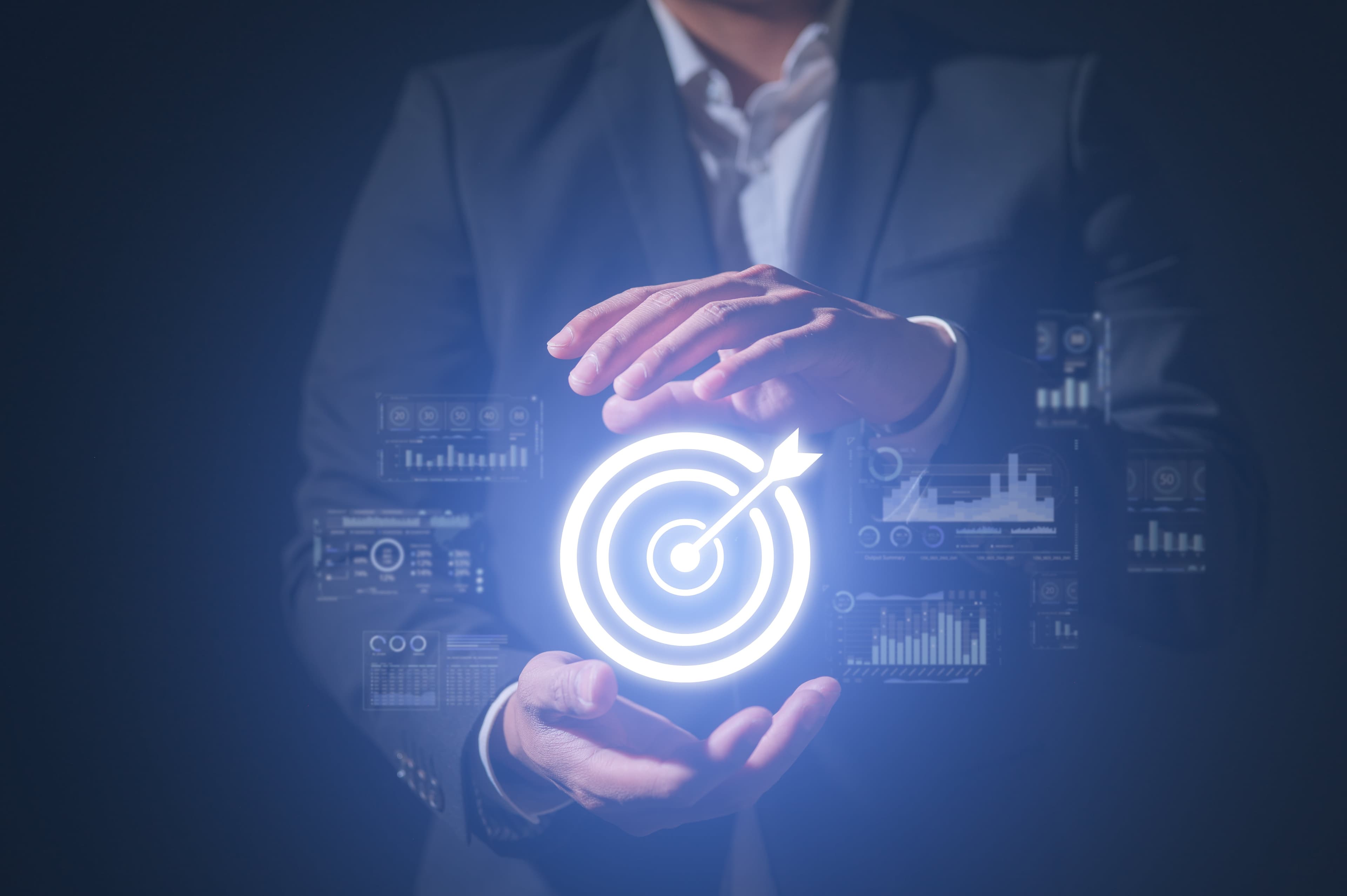 Geschäftsmann hält ein digitales Zielsymbol mit umgebenden Datenanzeigen Geschäftsmann hält ein digitales Zielsymbol mit umgebenden Datenanzeigen