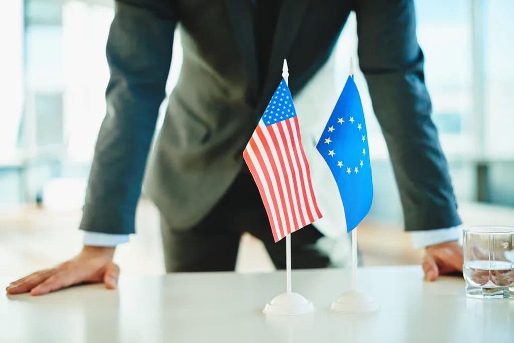 Drapeau de l’Europe et drapeau des États-Unis devant un homme d’affaire