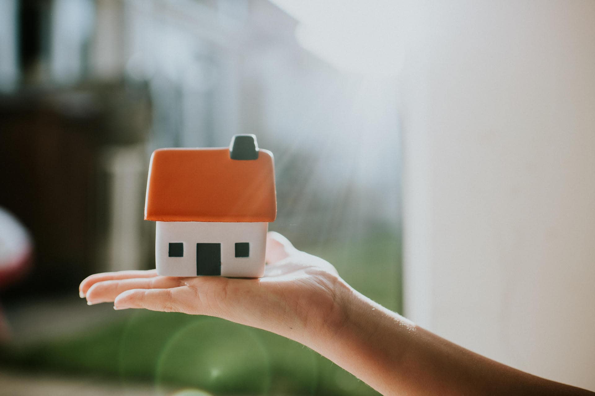 Une maison posée sur une main Une maison posée sur une main