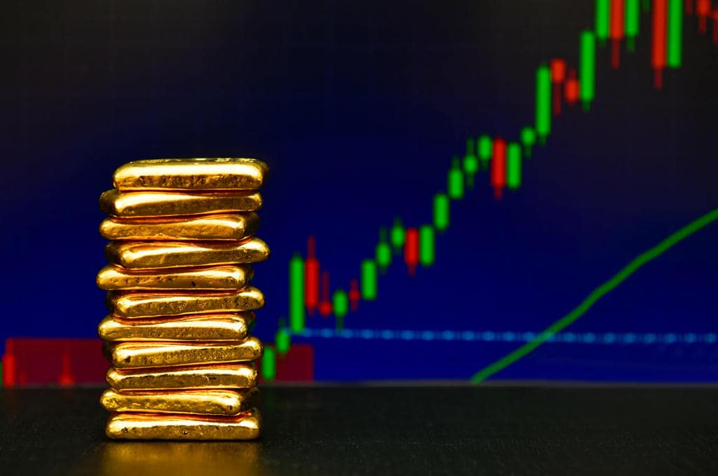 pile of gold bars in front of a chart pile of gold bars in front of a chart