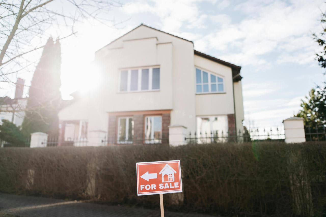 Ackerland kaufen: Eine gute Investition? Ein zu verkaufendes Haus mit einem Schild „zu verkaufen“.