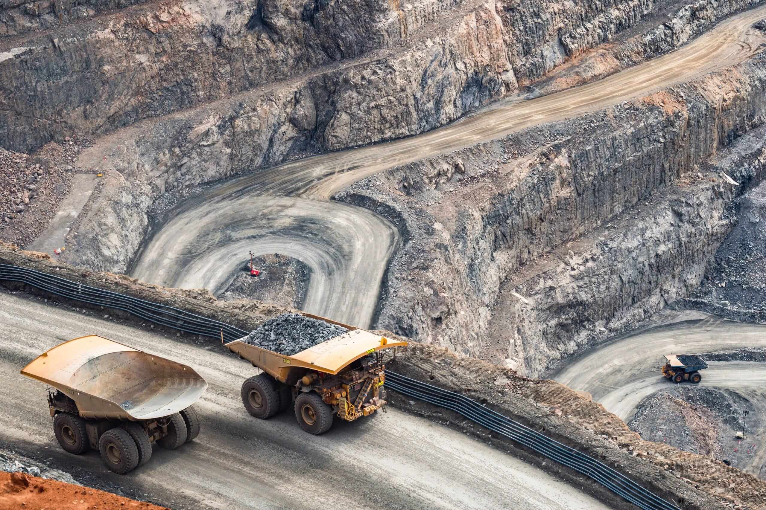 gold mining site with construction vehicles carrying rocks gold mining site with construction vehicles carrying rocks