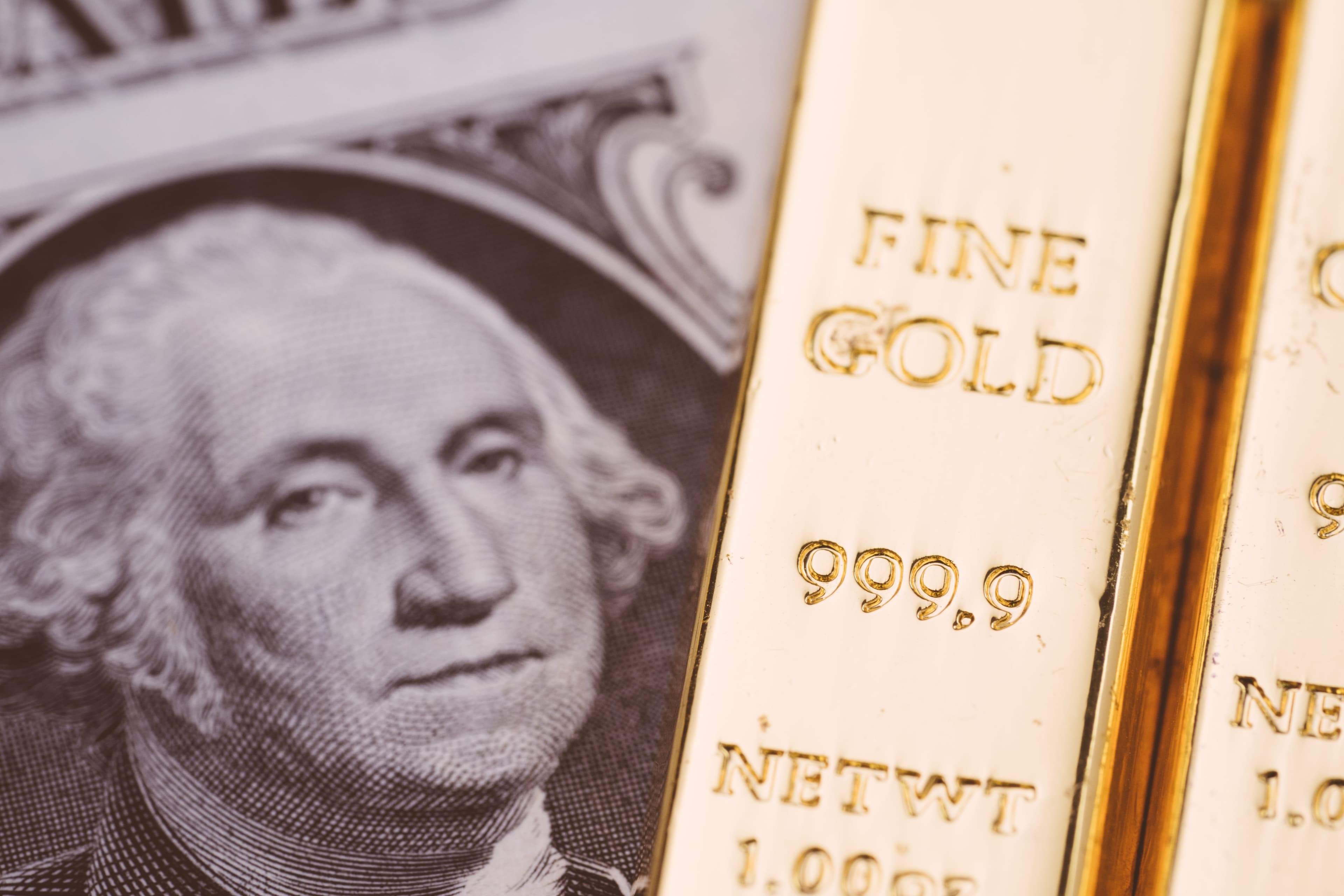 Der Goldstandard: Relikt oder Zukunftsmodell? Goldbarren auf einer US-Dollarnote