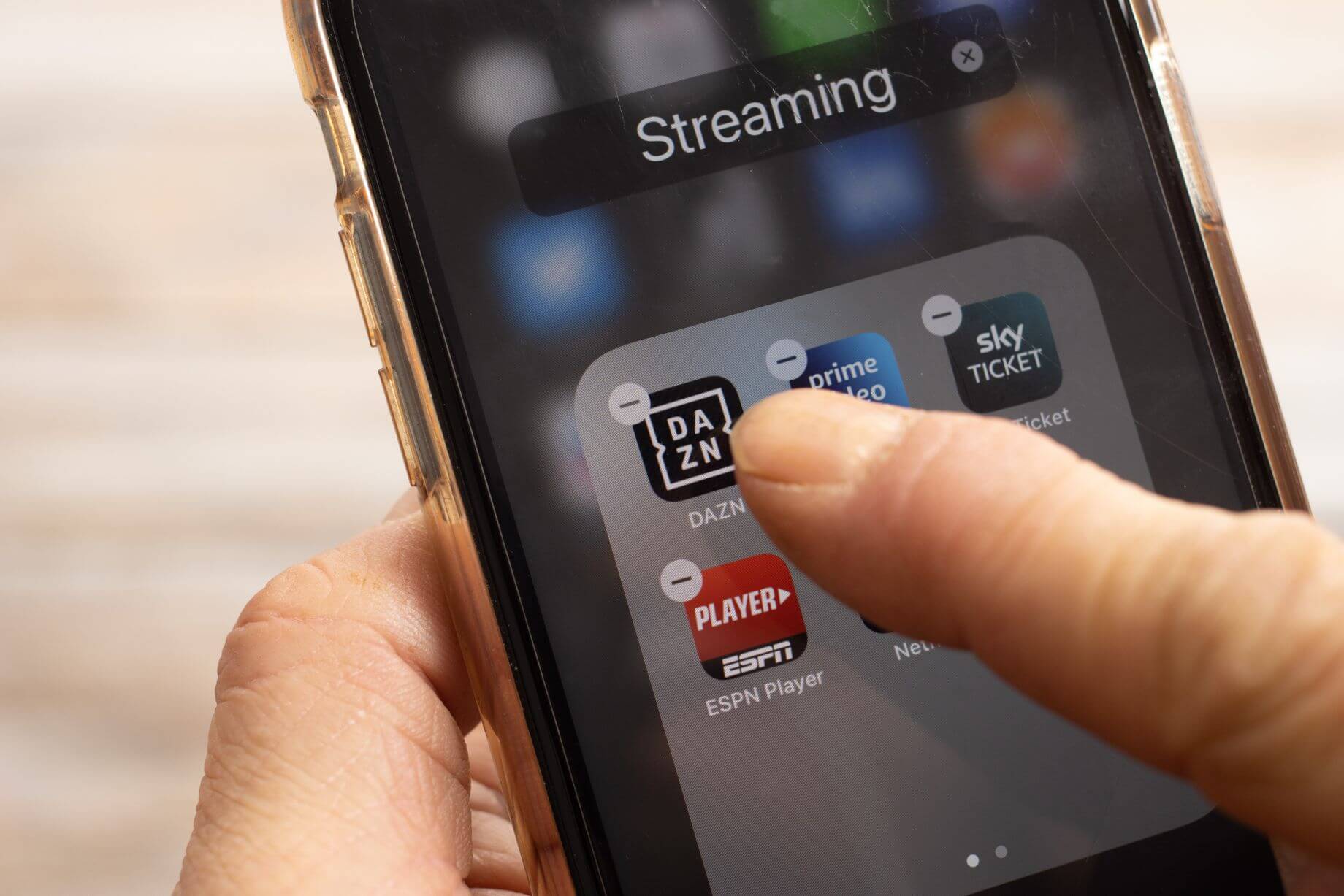 Ein Bild von einem Mann, der Streaming-Apps von seinem Smartphone löscht, um Geld zu sparen Ein Bild von einem Mann, der Streaming-Apps von seinem Smartphone löscht, um Geld zu sparen