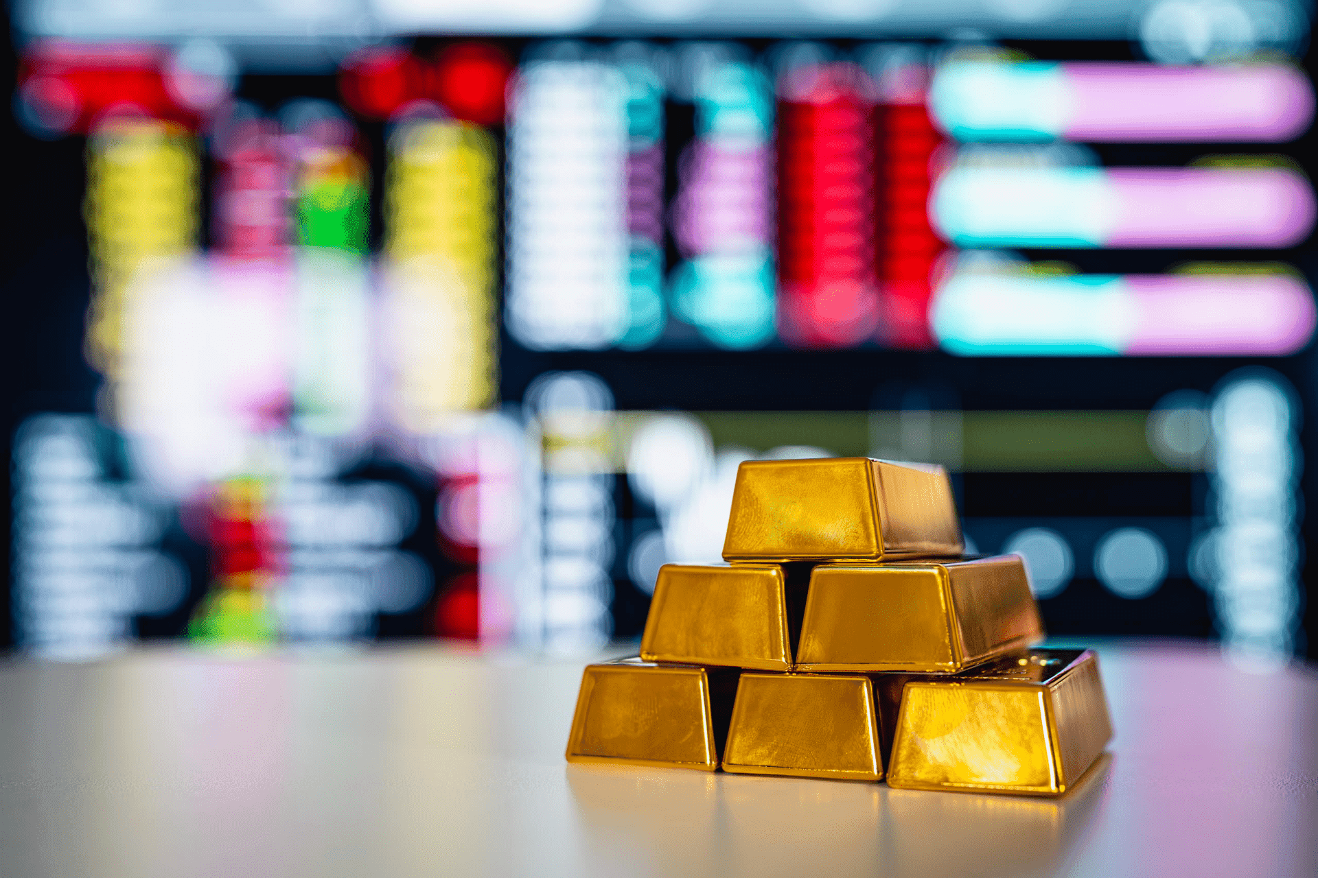 lingotti d’oro davanti a schermi con borsa valori lingotti d’oro davanti a schermi con borsa valori