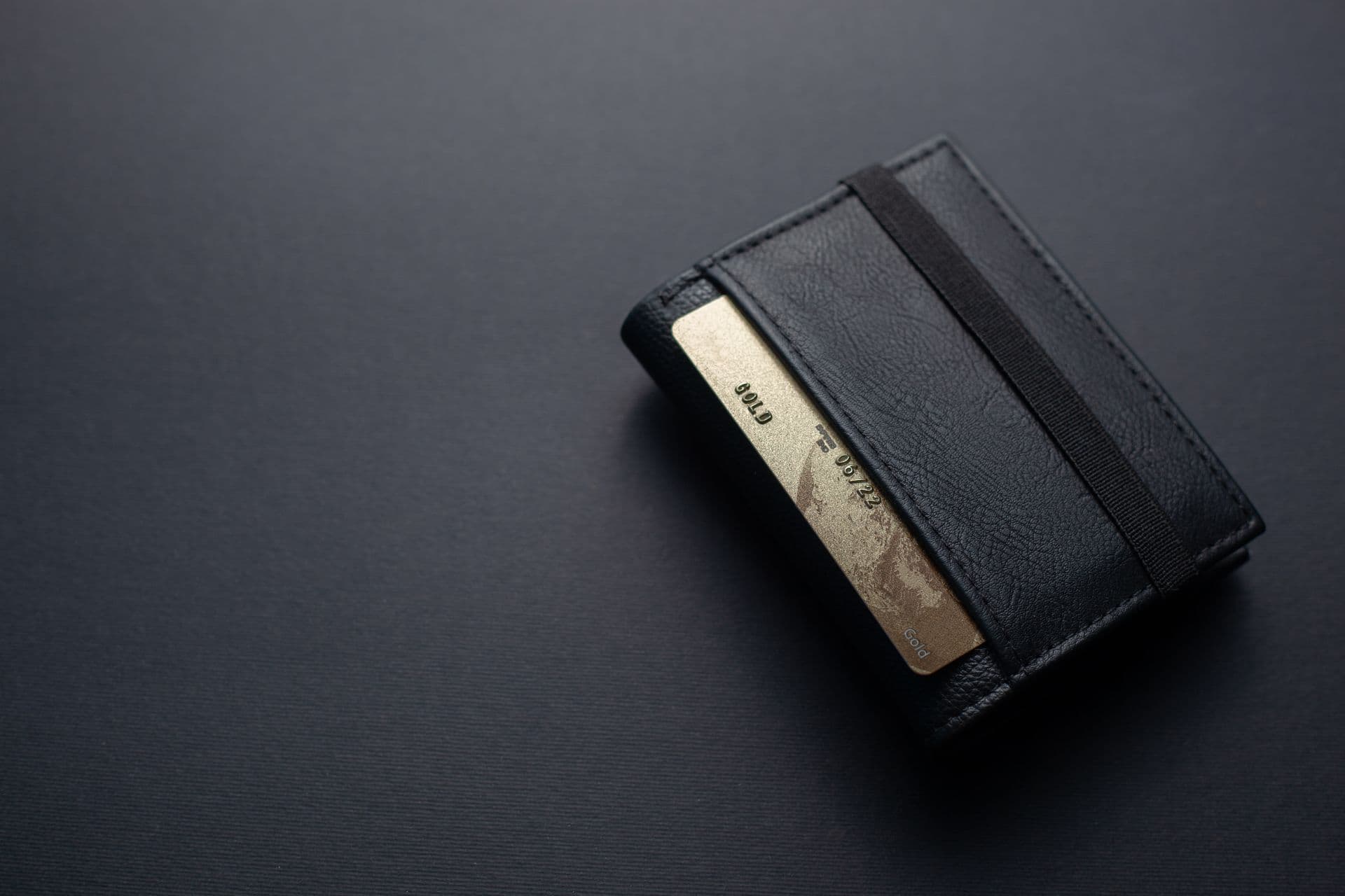 un portefeuille noir avec une carte de crédit dorée un portefeuille noir avec une carte de crédit dorée