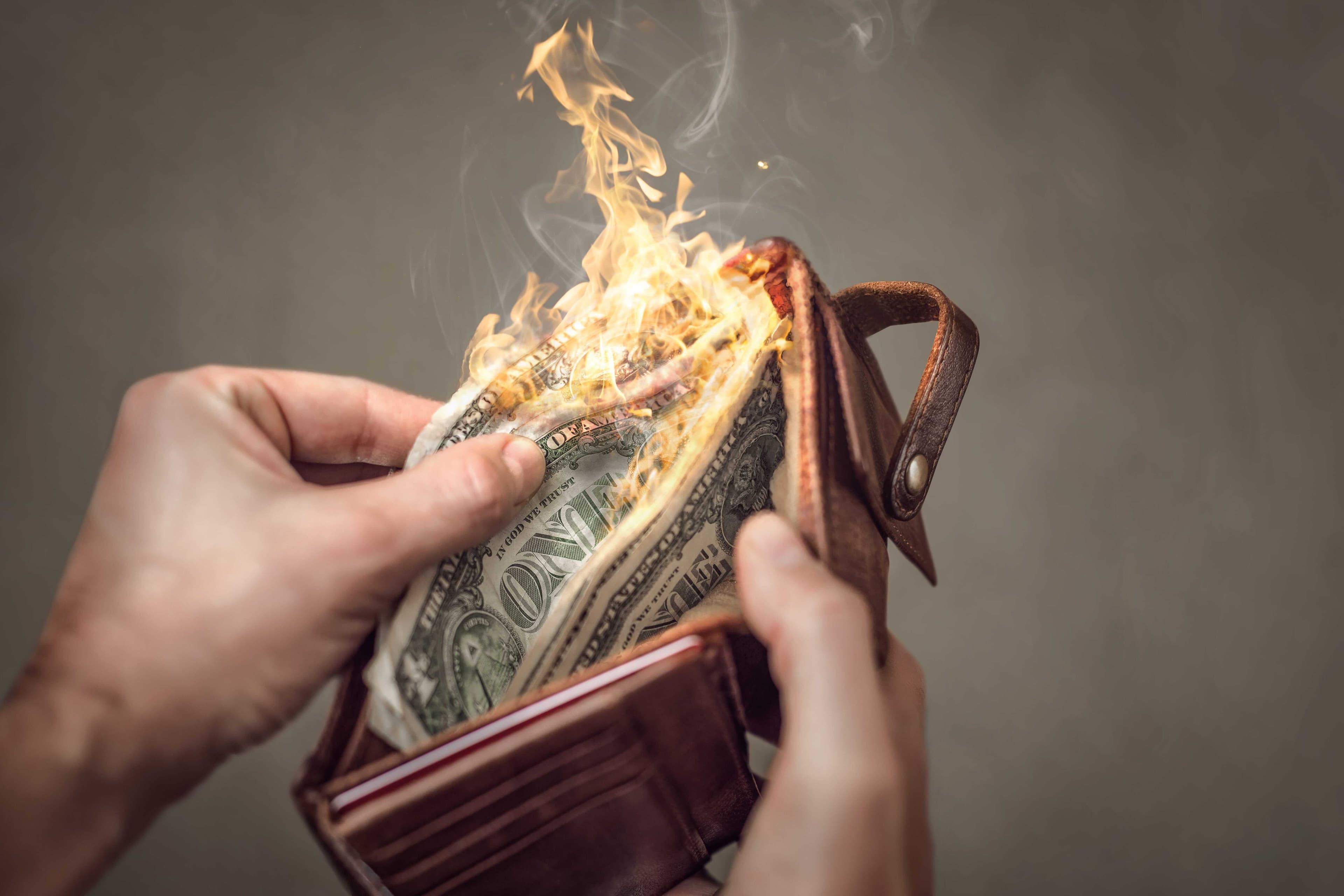 Des billets brûlant dans le portefeuille d'un homme. Des billets brûlant dans le portefeuille d'un homme.
